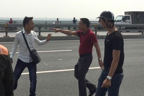 Nhà báo Quang Thế (áo trắng) bị hành hung khi đang tác nghiệp trên cầu Nhật Tân. (Nguồn: Báo Tuổi Trẻ)