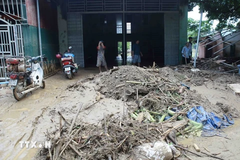 Các hộ dân ở xã Cốc San, huyện Bát Xát, Lào Cai thu dọn bùn do lũ quét. (Ảnh: Trần Việt/TTXVN)