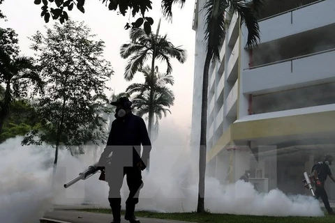 Nhân viên y tế phun thuốc diệt muỗi truyền virus Zika tại khu vực Aljunied, Singapore ngày 28/8. (Nguồn: AFP/TTXVN)