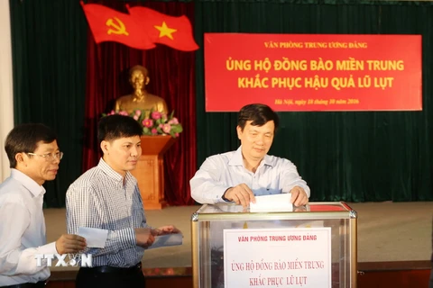 Cán bộ, chuyên viên, người lao động Văn phòng Trung ương Đảng tham gia quyên góp ủng hộ đồng bào miền Trung. (Ảnh: Trí Dũng/TTXVN) 