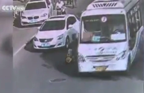 Đứa trẻ lái xe đồ chơi băng qua đường dù rất nhiều ôtô đang chạy. (Nguồn: CCTV)