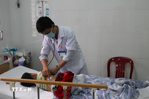 Cháu Nguyễn Giác Sáng được người nhà chăm sóc tại bệnh viện. (Ảnh: Ngọc Minh/TTXVN)