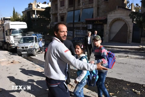 Sơ tán các em học sinh khỏi một trường học sau khi ngôi trường này bị phiến quân tấn công ở Aleppo ngày 20/11. (Nguồn: AFP/TTXVN)