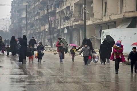 Người dân Syria sơ tán khỏi các khu vực do quân nổi dậy kiểm soát để đến các khu vực đã được quân Chính phủ giải phóng ở Aleppo ngày 13/12. (Nguồn: AFP/TTXVN) 