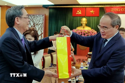 Chủ tịch Ủy ban Trung ương Mặt trận Tổ quốc Việt Nam Nguyễn Thiện Nhân chúc tết và tặng quà cho các kiều bào tiêu biểu. (Ảnh: Thế Anh/TTXVN)