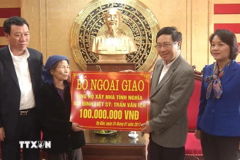 Phó Thủ tướng Chính phủ Phạm Bình Minh trao tặng thân nhân liệt sỹ Trần Văn Ích 100 triệu đồng xây dựng nhà tình nghĩa. (Ảnh: Nguyễn Lành/TTXVN)