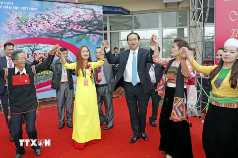 Chủ tịch nước Trần Đại Quang cùng tham gia điệu múa xòe với cộng đồng các dân tộc Việt Nam và bà con kiều bào về dự Ngày hội. (Ảnh: Nhan Sáng/TTXVN)