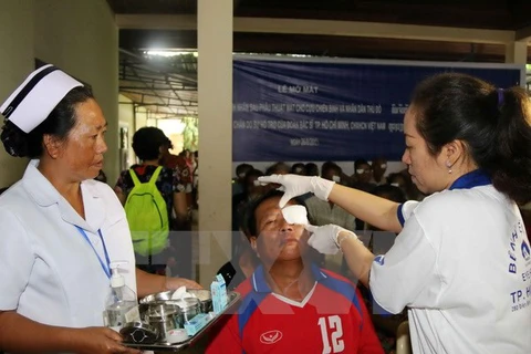 Bác sỹ Việt Nam và Lào đang tiến hành kiểm tra, mở băng mắt cho một bệnh nhân sau khi mổ. (Ảnh minh họa: TTXVN)