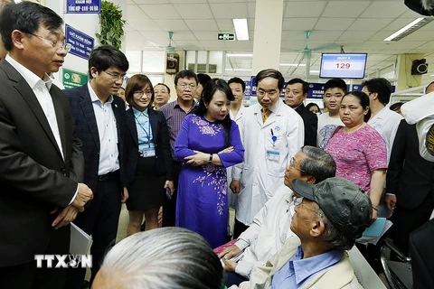 Bộ trưởng Nguyễn Thị Kim Tiến tiếp xúc với người bệnh để kiểm tra công tác chuyên môn tại Bệnh viện Đa khoa Xanh Pôn. (Ảnh: Dương Ngọc/TTXVN)