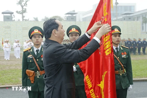 Chủ tịch nước Trần Đại Quang gắn Huân chương Quân công hạng Nhất lên lá cờ truyền thống của Bộ Tư lệnh Binh chủng Đặc công. (Ảnh: Nhan Sáng/TTXVN)
