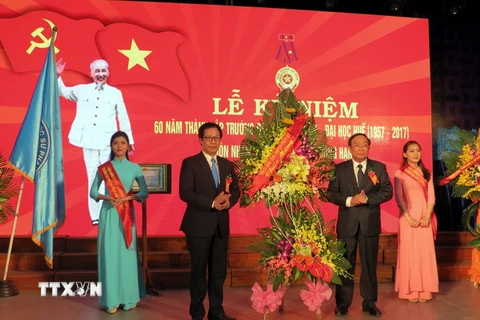 Chủ tịch Ủy ban Nhân dân tỉnh Thừa Thiên-Huế Nguyễn Văn Cao (bên phải) tặng hoa chúc mừng Trường Đại học Sư phạm Huế nhân kỷ niệm 60 năm thành lập. (Ảnh: Quốc Việt/TTXVN)