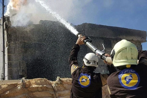Phun nước dập một đám cháy sau vụ không kích. (Nguồn: AP)