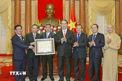 Chủ tịch nước Trần Đại Quang tặng quà cho Đoàn đại biểu kiều bào Việt Nam tại Thái Lan. (Ảnh: Nhan Sáng/TTXVN)