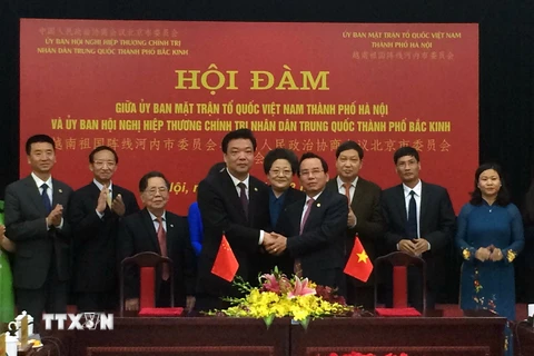 Chủ tịch Ủy ban Mặt trận Tổ quốc Việt Nam thành phố Hà Nội Vũ Hồng Khanh và Chủ tịch Chính hiệp Bắc Kinh Cát Lâm bắt tay giao lưu. (Ảnh: Minh Huệ/TTXVN)