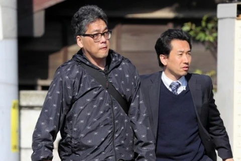 Shibuya Yasumasa (trái) bị áp giải lên xe cảnh sát. (Nguồn: Asahi Shimbun)