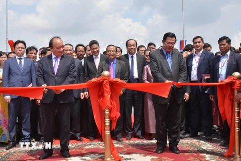 Thủ tướng Nguyễn Xuân Phúc và Thủ tướng Samdech Techo Hun Sen cắt băng khánh thành cầu Long Bình-Chrey Thom. (Ảnh: Công Mạo/TTXVN)