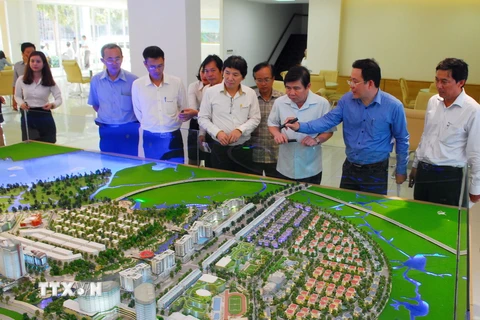 Ông Nguyễn Thành Phong, Chủ tịch UBND Thành phố Hồ Chí Minh (thứ 3 từ phải qua) khảo sát sơ đồ mô hình các công trình Khu đô thị Thủ Thiêm. (Ảnh: Mạnh Linh/TTXVN)