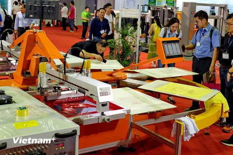 Khách đến xem triển lãm quốc tế công nghệ in lụa và kỹ thuật số lần đầu tiên ở Việt Nam. (Ảnh: Hoàng Hải/Vietnam+)