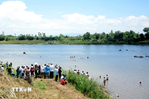 Lực lượng cứu hộ tìm kiếm thi thể học sinh bị đuối nước trên sông Ba. (Ảnh: Thế Lập/TTXVN)