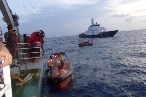 Các xuồng của Việt Nam cập mạn tàu Indonesia để đón ngư dân. (Ảnh: Đỗ Quyên/TTXVN)