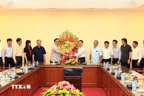 Ông Hoàng Trung Hải, Ủy viên Bộ Chính trị, Bí thư Thành ủy Thành phố Hà Nội đến tặng hoa chúc mừng cán bộ, phóng viên, biên tập viên của T​TXVN. (Ảnh: Quốc Khánh/TTXVN)