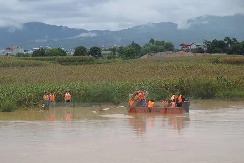 Các lực lượng chức năng tìm kiếm nạn nhân mất tích trên sông Nậm Rốm. (Ảnh: Xuân Tiến/TTXVN)