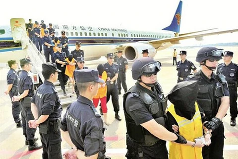Những nghi phạm Trung Quốc bị dẫn độ từ Campuchia về nước sau khi bị bắt vì cáo buộc lừa đảo qua điện thoại hồi tháng 7/2014. (Nguồn: Xinhua)
