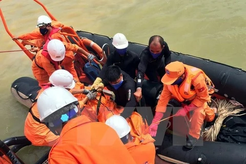 Lực lượng Trung tâm phối hợp tìm kiếm cứu nạn hàng hải Việt Nam đưa thi thể thuyền viên được tìm thấy mặc kẹt trong tàu VTB 26 lên tàu để đưa vào đất liền. (Ảnh: Tá Chuyên/TTXVN) 