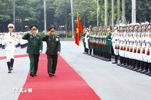 Thượng tướng Lương Cường và Trung tướng Vilay Lakhamphong duyệt đội danh dự Quân đội Nhân dân Việt Nam. (Ảnh: An Đăng/TTXVN)