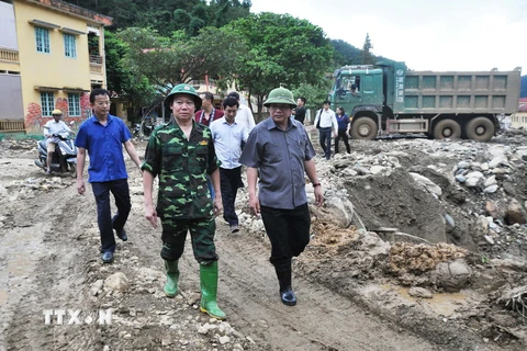 Bộ trưởng Trương Minh Tuấn (bên phải) thị sát vùng thiệt hại do lũ. (Ảnh: Đinh Hữu Dư/TTXVN)