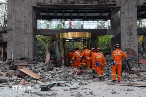 Nhân viên cứu hộ làm nhiệm vụ tại tòa nhà bị sập do động đất tại Tứ Xuyên ngày 9/8. (Nguồn: THX/TTXVN)