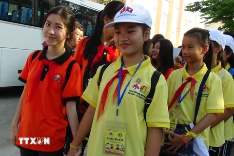 Thiếu nhi Việt Nam (áo màu đỏ) nắm chặt tay thiếu nhi Lào, biểu thị cho tình đoàn kết hữu nghị đặc biệt, sự hiểu biết lẫn nhau giữa thiếu nhi hai nước. (Ảnh: Phan Sáu/TTXVN)