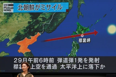Bản tin về việc Triều Tiên phóng tên lửa qua lãnh thổ Nhật Bản được phát ở một địa điểm công cộng ở Tokyo. (Nguồn: Reuters) 