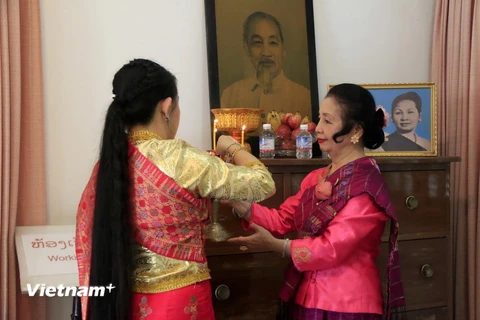 Bà Nhotkeomaly Suphanouvong và con gái đang chuẩn bị đồ lễ thắp hương tại Bàn thờ Chủ tịch Hồ Chí Minh trong Khu lưu niệm Chủ tịch Suphanouvong ở thủ đô Vientiane. (Ảnh: Phạm Kiên/Vietnam+)
