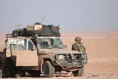 Lính Mỹ đứng cạnh một xe quân sự ở phía bắc thành phố Raqqa. (Nguồn: Reuters)