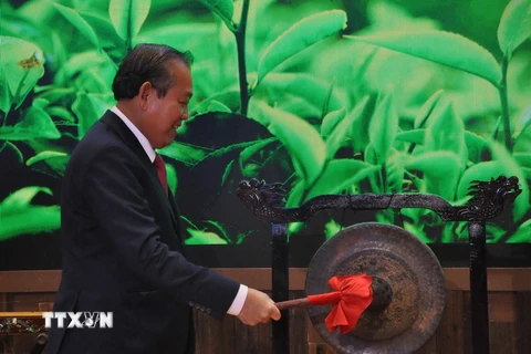 Phó Thủ tướng Thường trực Chính phủ Trương Hòa Bình đánh chiêng tại Lễ khai trương Khu gian hàng quốc gia tại Hội chợ Trung Quốc-ASEAN. (Ảnh : Lê Trung Kiên/TTXVN)