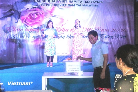 Đại sứ Việt Nam tại Malaysia Lê Quý Quỳnh quyên góp ủng hộ đồng bào vùng lũ. (Ảnh: Hoàng Nhương/Vietnam+)