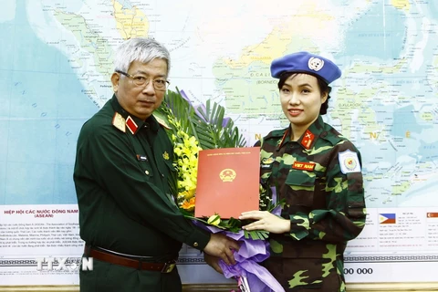 Thượng tướng Nguyễn Chí Vịnh trao Quyết định của Chủ tịch nước cho Thiếu tá Đỗ Thị Hằng Nga. (Ảnh: An Đăng/TTXVN)