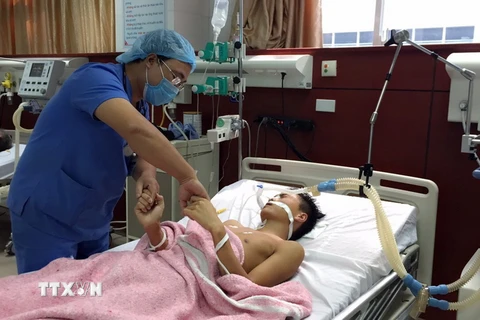 Bác sỹ tại Bệnh viện Đa khoa tỉnh Bắc Ninh thăm khám cho bệnh nhân Nguyễn Đức Khải. (Ảnh: Thanh Thương/TTXVN)