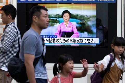 Người đi bộ ở Tokyo, Nhật Bản đi ngang qua một màn hình đang phát thông tin về vụ phóng tên lửa của Triều Tiên. (Nguồn: Getty Images)
