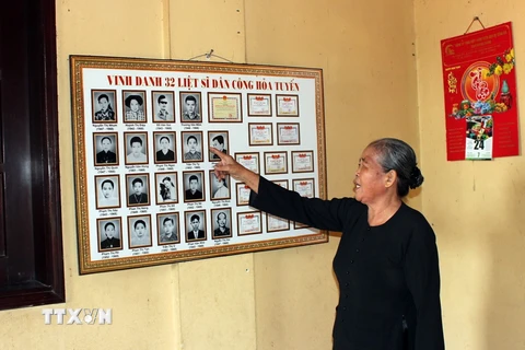 Bà Phạm Thị Ôi chia sẻ thông tin những liệt sỹ, là đồng đội trong đoàn dân công hỏa tuyến năm xưa. (Ảnh: Tiến Lực/TTXVN)