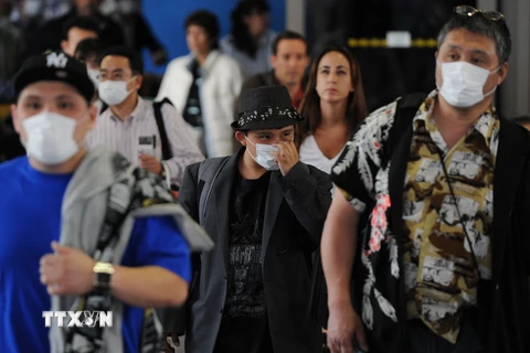 Khách du lịch sử dụng khẩu trang phòng dịch cúm lây lan tại sân bay quốc tế Los Angeles, Mỹ. (Nguồn: AFP/TTXVN)