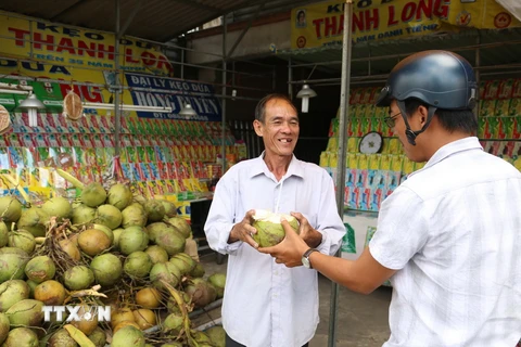 Người tiêu dùng mua dừa tươi Bến Tre. (Ảnh: Huỳnh Phúc Hậu/TTXVN)