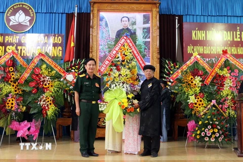 Đại diện Bộ Tư lệnh Quân Khu 9 tặng hoa chúc mừng Đại lễ Đản sinh Đức Huỳnh Giáo chủ Phật giáo Hòa Hảo Huỳnh Phú Sổ. (Ảnh: Vương Thoại Trung/TTXVN)