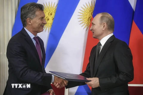 Tổng thống Nga Vladimir Putin (phải) và người đồng cấp Argentina Mauricio Macri trao đổi văn kiện sau lễ ký thỏa thuận tại Moskva, Nga ngày 23/1. (Nguồn: AFP/TTXVN)