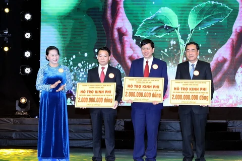 Chủ tịch Quốc hội Nguyễn Thị Kim Ngân trao tượng trưng tiền hỗ trợ cho đại diện các tỉnh. (Ảnh: Trọng Đức/TTXVN) 