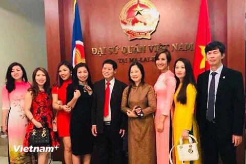 Đại sứ Lê Quý Quỳnh và phu nhân chụp ảnh kỷ niệm cùng một số bà con cộng đồng. (Ảnh: Lê Hòa/Vietnam+)