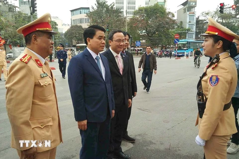 Chủ tịch Ủy ban Nhân dân thành phố Hà Nội Nguyễn Đức Chung và các đại biểu với lực lượng cảnh sát giao thông Hà Nôi làm nhiệm vụ tại phố Cửa Nam-Điện Biên Phủ. (Ảnh: Doãn Tấn/TTXVN)