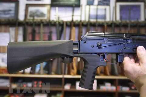 Thiết bị 'bump stock' (trái) được gắn vào khẩu súng bán tự động AK-47 (phải) tại một cửa hàng ở bang Utah, Mỹ ngày 1/10. (Nguồn: AFP/TTXVN)