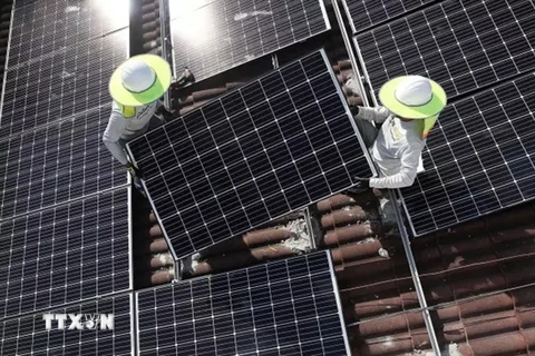 Lắp đặt các tấm pin năng lượng Mặt Trời của Công ty năng lượng Goldin. (Nguồn: AFP/TTXVN)